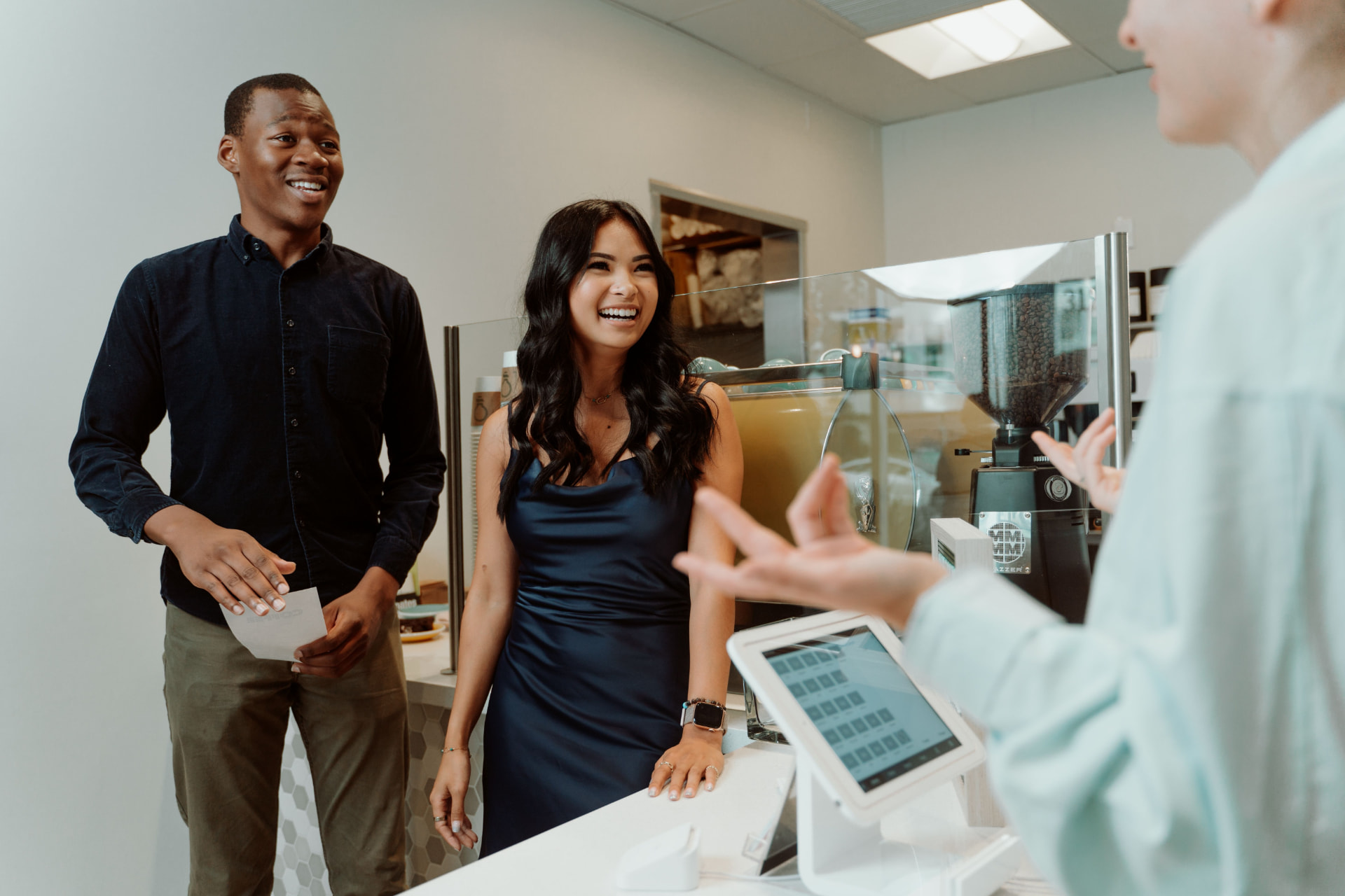 A friendly team welcoming customers at the counter of a small business